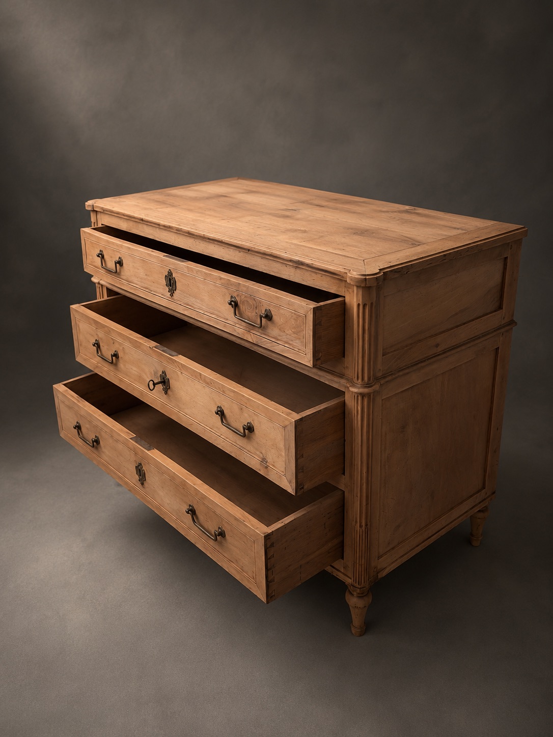 Commode ancienne, les trois tiroirs ouverts, vue de trois quarts